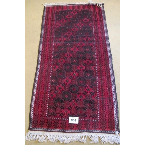 861 - A 20th Century Persian Baluch rug, repeat pattern on red ground. 200cm x 98cm approx.
Condition repo... 