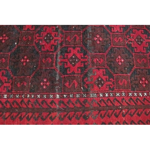 861 - A 20th Century Persian Baluch rug, repeat pattern on red ground. 200cm x 98cm approx.
Condition repo... 