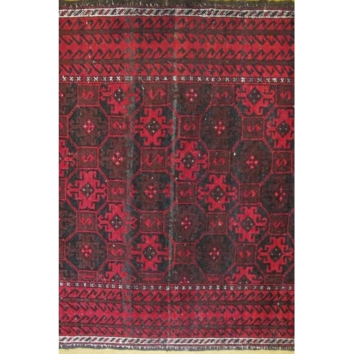 861 - A 20th Century Persian Baluch rug, repeat pattern on red ground. 200cm x 98cm approx.
Condition repo... 