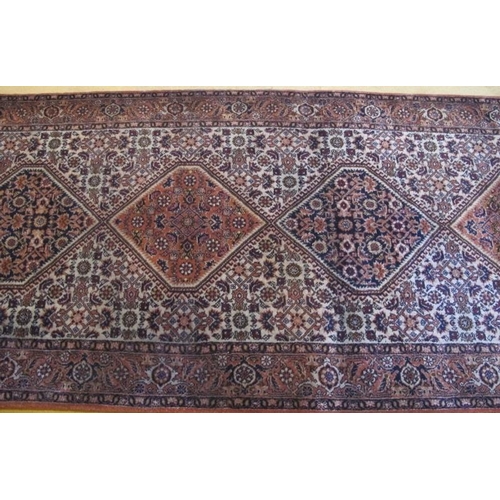 862 - A 20th Century Persian runner, nine central interlocking panels on muted creams/pink. 472cm x 92cm a... 