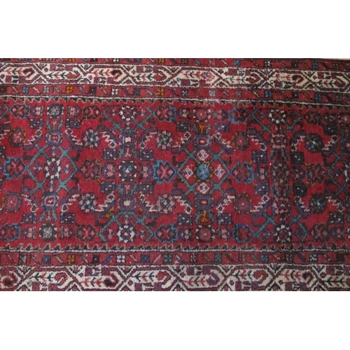 863 - A 20th Century Persian runner, central pattern on red ground with cream border. 389cm x 81cm approx.... 