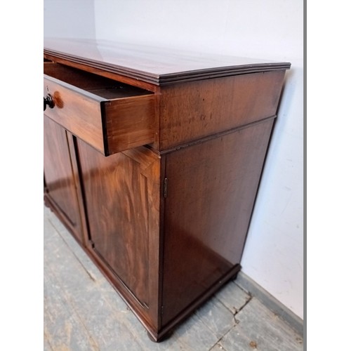 750A - A Regency Period flame mahogany linen cupboard, the top with reeded edge, housing two short drawers ... 