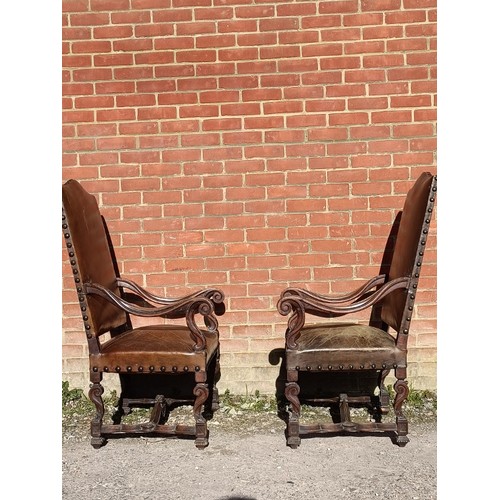 718A - A pair of antique French walnut fauteuil throne chairs, the ornately carved frames upholstered in di... 