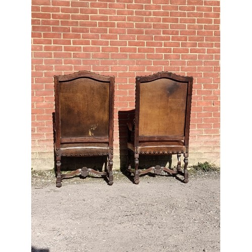 718A - A pair of antique French walnut fauteuil throne chairs, the ornately carved frames upholstered in di... 