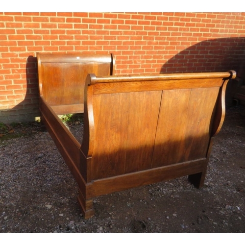 733 - A 19th Century French oak sleigh bed complete with side rails and bolts.  H110cm x W116cm x D208cm a... 