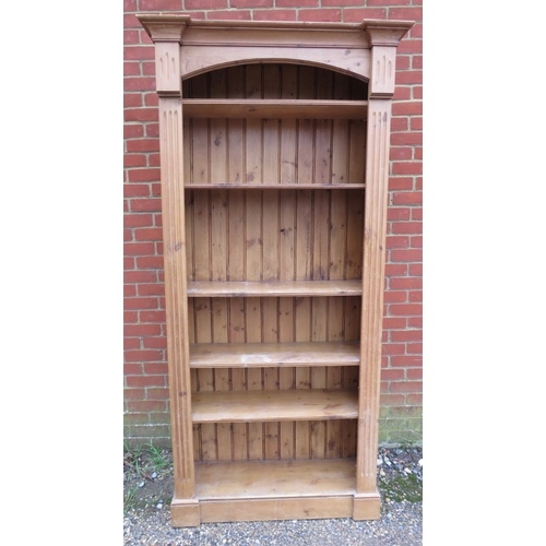 743 - A 20th Century tall pine freestanding open bookcase with adjustable shelves flanked either side by r... 