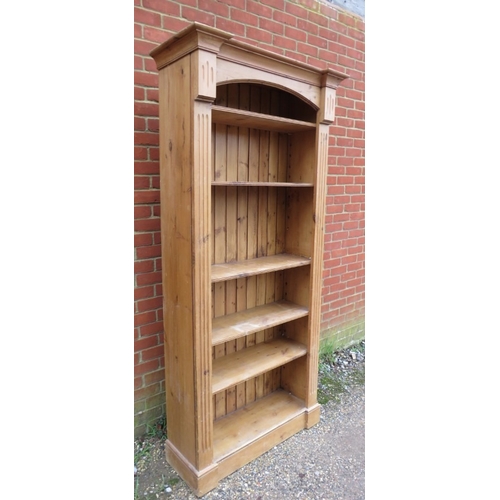 743 - A 20th Century tall pine freestanding open bookcase with adjustable shelves flanked either side by r... 