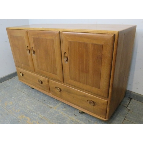 747 - An Ercol sideboard with three cupboard doors over two long drawers, each with dished wooden handles ... 
