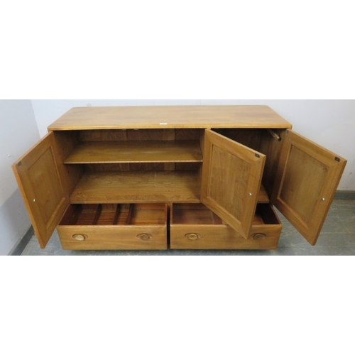 747 - An Ercol sideboard with three cupboard doors over two long drawers, each with dished wooden handles ... 