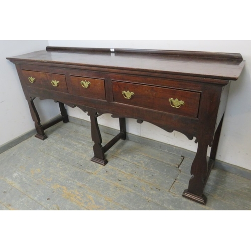 751 - A C1900 mahogany sideboard with three drawers each with brass handles over an ornate six legged supp... 