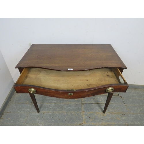 794 - A 19th Century mahogany bow fronted side table with a single frieze drawer.  Brass oval handles and ... 