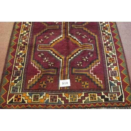 810 - A South West Persian Lori rug with a linked pattern central panel on a plum ground.  270cm x 138cm a... 