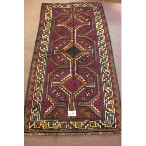 810 - A South West Persian Lori rug with a linked pattern central panel on a plum ground.  270cm x 138cm a... 