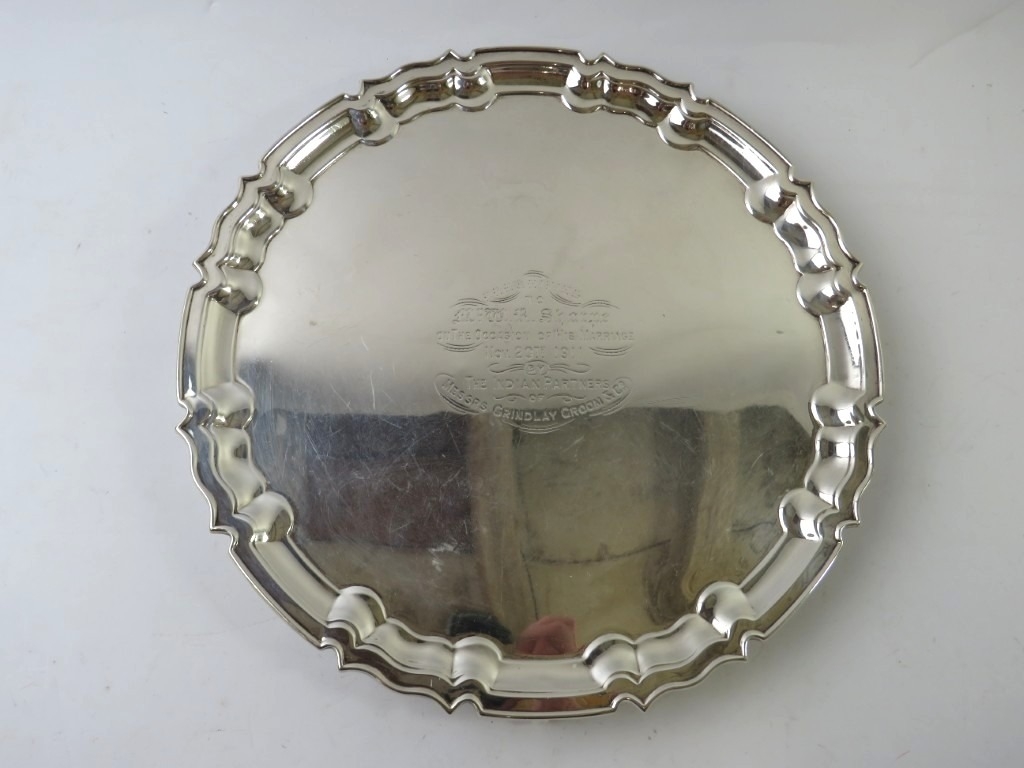 An Edwardian silver salver with pie crust rim and standing on three ...