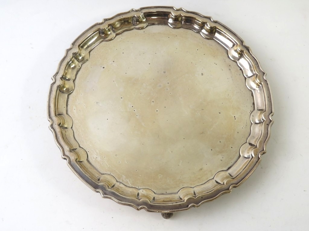 An early 20th century silver salver with pie crust rim and three ...