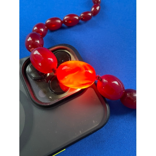 11 - Graduated Cherry Amber Bakelite Necklace With 9ct Gold Clasps. Weighing 44.33g Gross On Knotted Stri... 