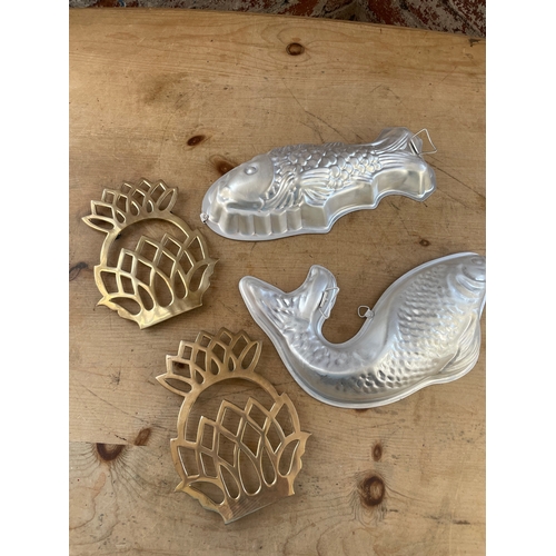 82 - Two Fish Shaped Mousse Moulds & Two Brass Pineapple Shaped Trivets