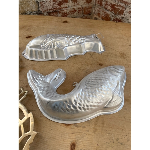 82 - Two Fish Shaped Mousse Moulds & Two Brass Pineapple Shaped Trivets