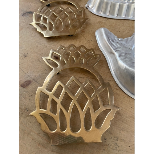 82 - Two Fish Shaped Mousse Moulds & Two Brass Pineapple Shaped Trivets