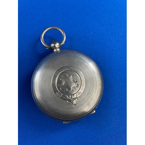 46 - 1901 Silver Pocket Watch With Ornate Metal Face. Ticks for a few seconds before sticking.