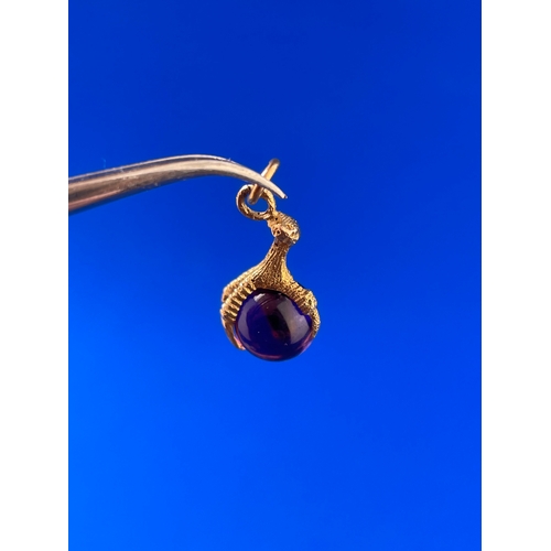 38 - 9ct Gold Eagle Claw Pendant Holding Amethyst Coloured Stone