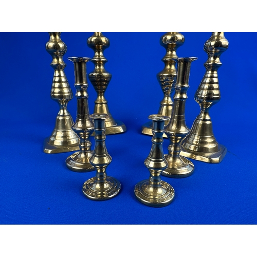 445 - Four Pairs of Brass Candle Sticks in Vrious Sizes.