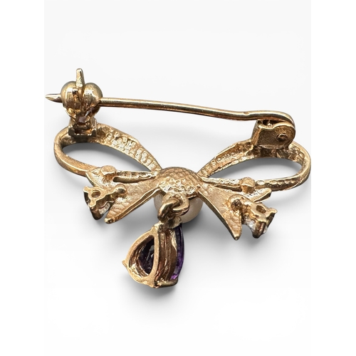25 - Nine Carat Gold Bow Brooch with Amethyst Dropper, Two Small Diamonds and Peal. 1.82g...