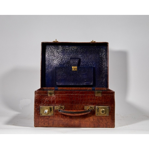 59 - Two brass-mounted brown crocodile leather travelling cases, early 20th century, the first by Leuchar... 