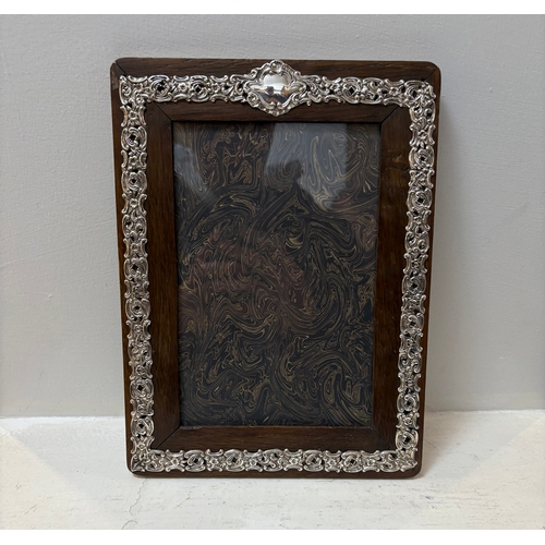 697 - EDWARDIAN SILVER PHOTO FRAME of rectangular form, with repousse decoration. 25 x 19 cm.