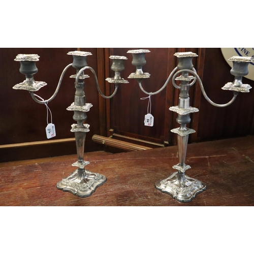 84 - A pair of silver plated three branch table candelabra on loaded bases. (2)
(B.P. 24% incl. VAT)