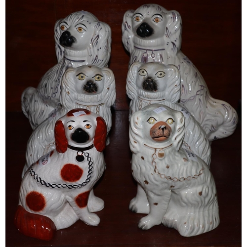 94 - Collection of Staffordshire pottery fireside spaniels of varying sizes with painted features, some p... 