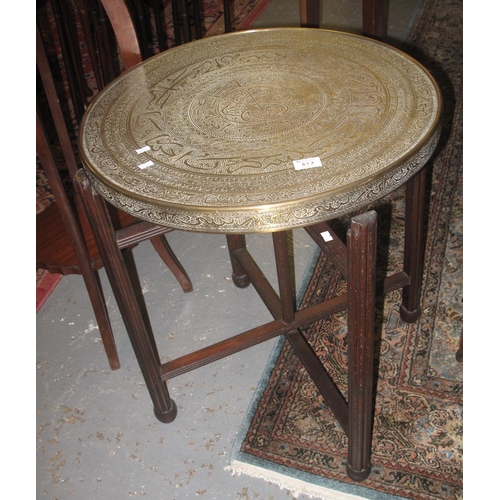 512 - Brass Middle Eastern design table on mahogany folding legs. 
(B.P. 21% + VAT)