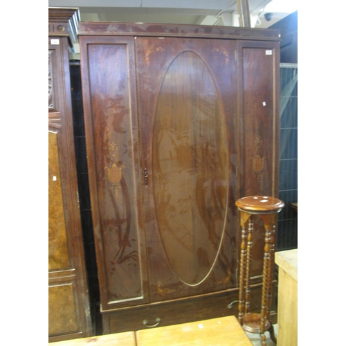 555 - Edwardian inlaid mahogany wardrobe with blind panel door and foliate decoration over under drawer.
(... 