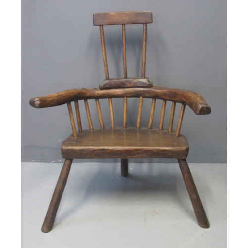 74 - PRIMITIVE OAK, ASH AND ELM COMB BACKED STICK BACKED ELBOW CHAIR having solid seat on three legs. 87c... 