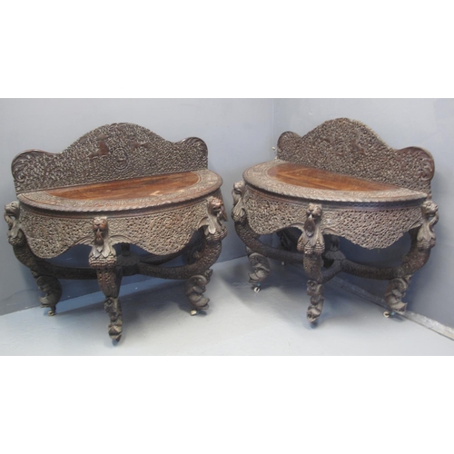 95 - PAIR OF 19TH CENTURY INDO-BURMESE PADOUK WOOD DEMI-LUNE SIDE TABLES each with raised copiously folia... 