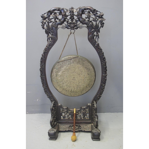 96 - 19TH CENTURY ORIENTAL PADOUK WOOD FLOOR STANDING GONG overall carved and pierced with floral designs... 