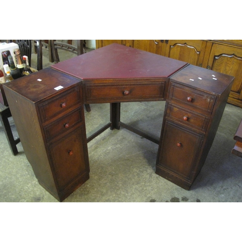 542 - Heals of London oak corner desk, having leather inset top above a central drawer. 
(B.P. 21% + VAT)