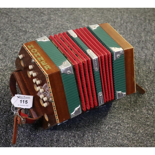 115 - Mahogany concertina with ivorine buttons to each end and checkered inlaid decoration.
(B.P. 21% + VA... 