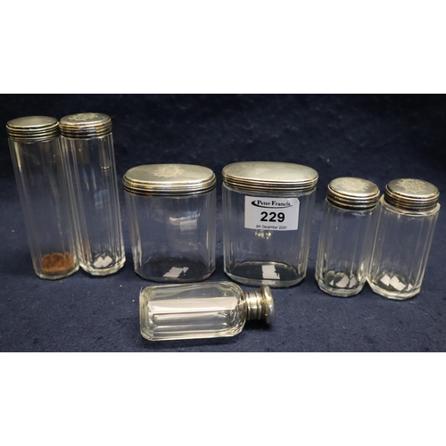 229 - A group of seven silver topped glass dressing table jars of different forms. Appearing to be three s... 