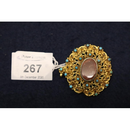 267 - A yellow metal filigree brooch set with turquoise, ruby and goldstone.  Approximate weight 13.4 gram... 