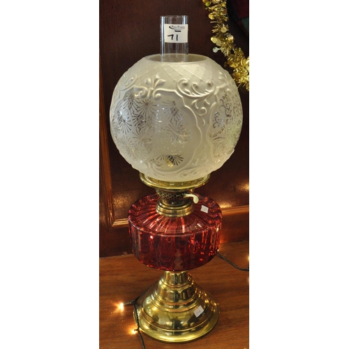 71 - Early 20th Century brass double burner oil lamp with cranberry glass reservoir on brass conical base... 