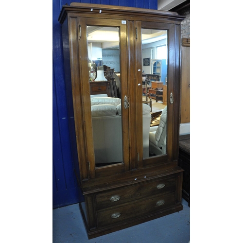 554 - Early 20th Century mahogany two door mirrored wardrobe on a base with two straight front drawers. 
(... 