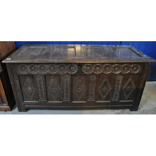 555 - 18th Century Welsh oak coffer having moulded four panel top above a carved flower head frieze with f... 