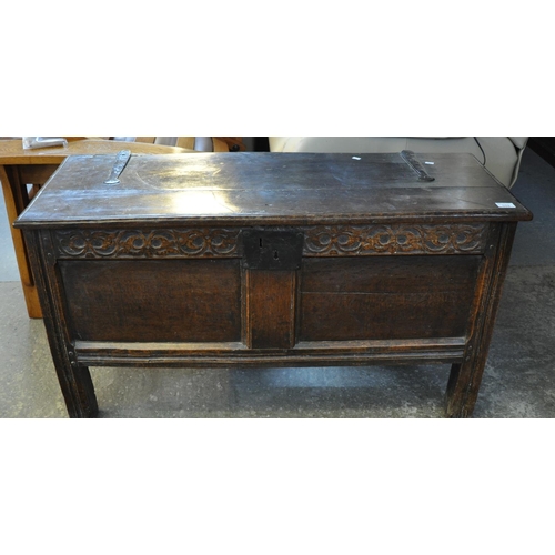 559 - 18th Century Welsh oak coffer, the moulded top above a carved frieze with metal lock, two fielded pa... 