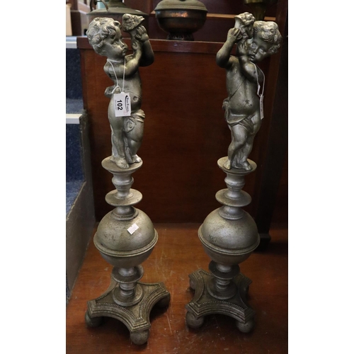 102 - Pair of heavy cast iron firedog supports decorated with cherubs on a quatreform concave base and bal... 