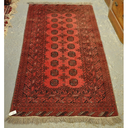 490 - Middle Eastern design red ground runner or rug having central geometric guls and foliate banding. 19... 