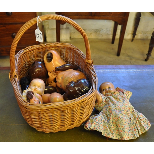 517 - Wicker basket containing assorted dolls and doll parts, heads, limbs etc. 
(B.P. 21% + VAT)