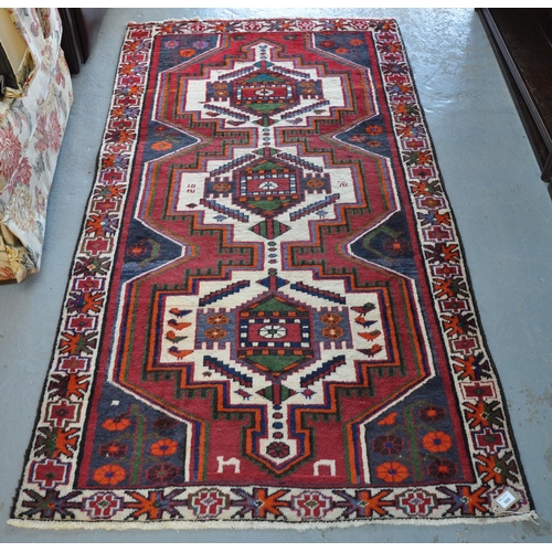 569 - Middle Eastern design multi-coloured carpet or runner with three central medallions of stylised bird... 