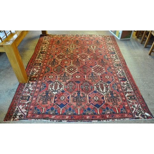 592 - Vintage washed red ground Persian Baktia carpet with Persian panel design. 268 x 205cm approx. 
(B.P... 