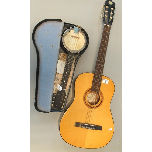 85 - Six string acoustic guitar, the label to the interior marked KC225. Together with a small banjo mand... 